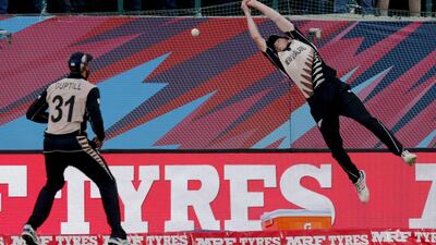 New Zealand’s Mitchell Santner is airborne as he attempts to take a catch in Dharamshala. He was unsuccessful. Ashwini Bhatia / AP Photo