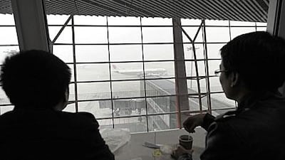 Travellers look at an airplane waiting for take off at Beijing International Airport last week. Hundreds of flights were cancelled due to fog.