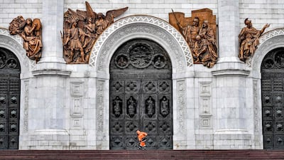 A worker clears the ice from the steps of the Cathedral of Christ the Saviour in Moscow, Russia. AFP