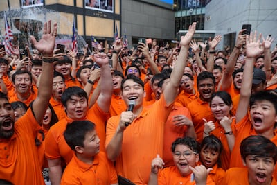 Nigel Ng, centre, dressed as Uncle Roger, celebrates with fans as they set a record for the largest gathering of people dressed up as Uncle Roger. EPA
