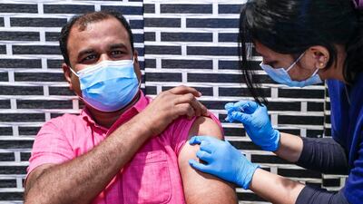 Sulaiman Kalathul gets vaccinated at the Biogenix Labs at G42 in Masdar City. Victor Besa / The National