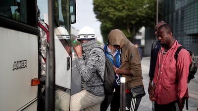 Migrants with their belongings board a bus as French police evacuate hundreds of migrants living in makeshift camps in Paris, France. Benoit Tessier / Reuters