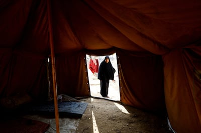 A displaced Palestinian woman stands outside a tent in the central Gaza Strip. Reuters