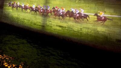 A light show is projected on the banks of the river Seine as part of the festivities ahead of tomorrow’s Qatar Prix de l’Arc de Triomphe. Maroon-and-silver banners adorn the Champs Elysees as well. Jacques Brinon / AP Photo