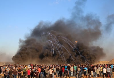 Israeli tear gas canisters arc through smoke from burning tyres during protests in Gaza on September 14, 2018. AFP