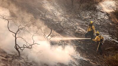 A firefighter uses a hose as the Silverado Fire approaches, near Irvine, California, U.S. October 26, 2020. REUTERS