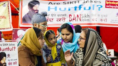 Lawyer Harvinder Chowdhury (right) explains her petition to Jaspal Kaur (left) and her children in New Delhi on November 25. Simon de Trey-White for The National