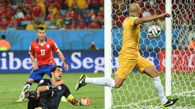 Chile keeper Claudio Bravo, left, makes a stop on Australia's Mark Bresciano, right, during their World Cup Group B match on Friday in Cuiaba, Brazil. William West / AFP