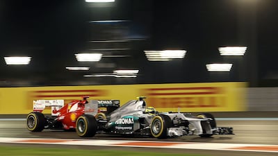 Fernando Alonso's Ferrari comes up behind Nico Rosberg's Mercedes during second practice at Yas. Jens Buettner / EPA