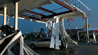 A car is trapped under the fallen metal roof of the Break Time petrol station in Jefferson City. AP Photo