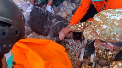Emergency personnel rescue a survivor from under rubble in Sikka, East Nusa Tenggara province. Reuters