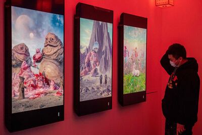 A man looks at digital paintings by US artist Beeple at a crypto art exhibition entitled “Virtual Niche: Have You Ever Seen Memes in the Mirror?”, one of the world's first physical museum shows of blockchain art, before its opening in Beijing on March 26. AFP