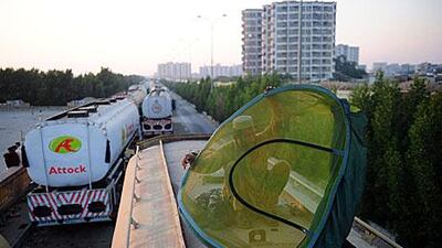 A Pakistan driver with Nato oil supplies packs away his tent on top of his trailer on December 18. Thousands of lorries are stuck at the Pakistan-Afghanistan border.