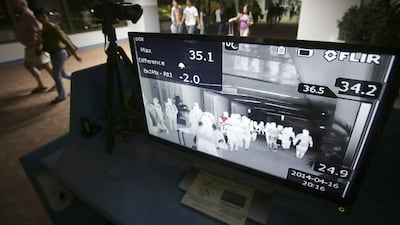 Passengers walk past a thermal scanner at Manila International Airport in the Philippines. The country is one of 18 that have reported cases of the MERS coronavirus. AP
