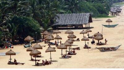 Tourists find shade under grass umbrellas on a beach in Colombo March 18, 2010. Sri Lanka's tourist arrivals jumped by nearly 70 percent in February compared to a year earlier to its highest level in over two years, boosted by the end of a 25-year war, according to the tourism board. REUTERS/Andrew Caballero-Reynolds (SRI LANKA - Tags: TRAVEL SOCIETY) *** Local Caption *** COL01_SRI-LANKA-_0318_11.JPG
