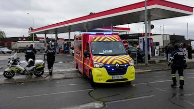 Firefighters secure the site of a petrol station where a man opened fire from his car in the Paris suburb of Trappes. AFP