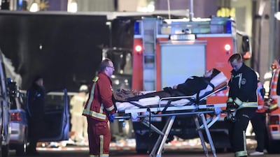 An injured person is carried on an stretcher by fireman at the scene where a truck crashed into a Christmas market, close to the Kaiser Wilhelm memorial church in Berlin. Police suspect a terror attack, with Interior Minister Thomas de Maiziere saying there are “many reasons” to believe the killings were deliberate. Clemens Bilan / EPA