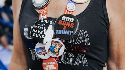 An attendee of the rally shows badges displaying 'Maga' messaging. President Joe Biden claimed adherents of Mr Trump's 'Make America Great Again' doctrine are undermining US democracy. Bloomberg