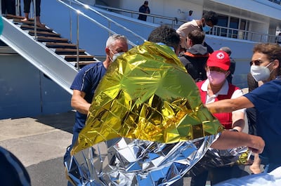 Greek paramedics help migrants arriving in Kalamata. EPA