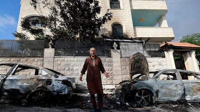 A man stands in front of burnt cars a day after an attack by Israeli settlers on the village of Jit near Nablus, in the occupied West Bank. AFP