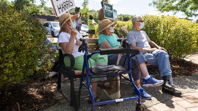 A woman holds a sign that reads 'Biden Harris' as protesters gather near another President Donald Trump campaign stop, this time in Minnesota.AFP