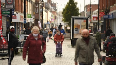 Shoppers wearing mask in the high street in Greater Manchester, northwest England. Tightening government restrictions coupled with falling consumer sentiment may hurt retail sales going forward. AFP