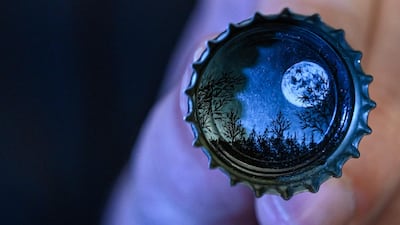 A moon landscape painted on a bottle cap
