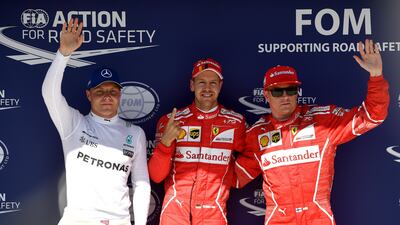 Sebastian Vettel, centre, will start at the front of the grid at the Hungarian Grand Prix. Ferrari teammate Kimi Raikonnen, right, will join the German on the front row. Andrej Isakovic / AFP