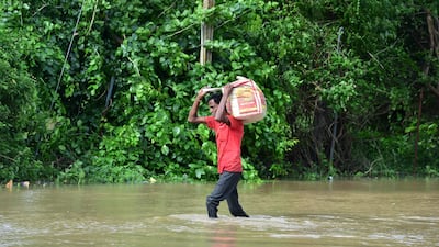 A man wades through a flooded street on the outskirts of Ahmedabad on Wednesday. AFP