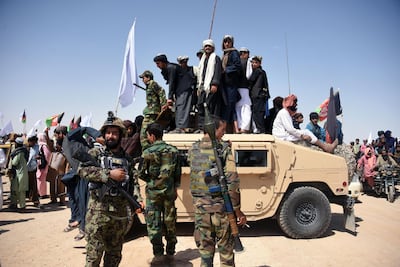 In this file photo taken in 2018, Afghan Taliban militants and residents stand on an armoured Humvee vehicle of the Afghan National Army. AFP