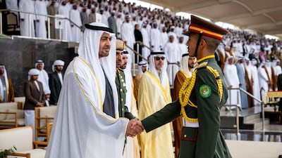 President Sheikh Mohamed wishes a graduate every success in his military career during the ceremony at Zayed II Military College. Photo: UAE Presidential Court