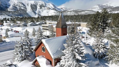 Workers remove snow piled up in front of a church in the Sierra Nevada mountains. AFP