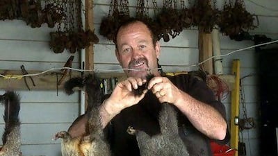 Trapper Stu Flett hangs out possum carcasses to dry in his garage at his home in Matapouri, on New Zealand's North Island. Erica Berenstein / AFP