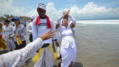 A Balinese woman in a trance gestures during a Melasti ceremony at Petitenget beach near Denpasar, Bali. AFP