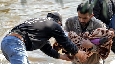 A child is carried across the river into Lebanon. AFP