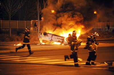 Firefighters pass a burning car during riots in Villiers-le-Bel in 2007. AFP