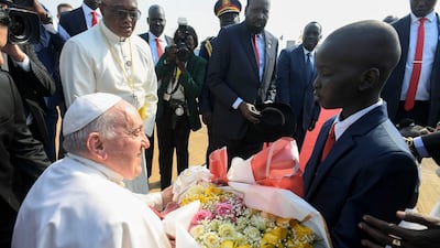 Pope Francis receives a bouquet of flowers from a child. AFP