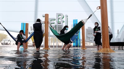 Expo visitors dip their feet in water to keep cool at the Brazil pavilion. Pawan Singh / The National