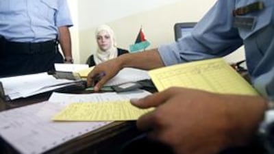 A Jordanian woman of Palestinian origin waits for a yellow card permit to be issued in place of her green permit in Amman.
