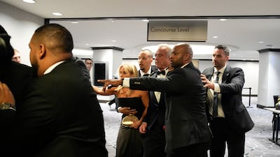 Law enforcement officers surround Robert F. Kennedy Jr. , US secretary of Health and Human Services (HHS), and his wife, actress Cheryl Hines following reports of a shooting during the White House Correspondents' Association (WHCA) dinner in Washington, DC, US on Saturday, April 25, 2026. President Donald Trump and Vice President JD Vance were evacuated from the White House Correspondents' Association dinner event in Washington Saturday following a security incident at the venue. Photographer: Yuri Gripas / Abaca / Bloomberg
