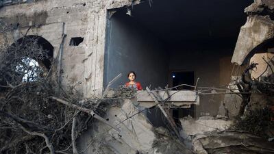 A Palestinian girl stands in a destroyed building following an Israeli military strike in Gaza City on Tuesday . The Israeli air force launched dozens of raids on the Gaza Strip overnight after massive rocket fire from the enclave pounded southern Israel, leaving 17 people injured, sources said. Mahmud Hams / AFP PHOTO