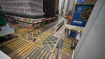 A pedestrian crosses an empty street in Hong Kong's central business district. The world’s toughest Covid-19 travel and quarantine restrictions are eroding the appeal of Asia’s main finance hub. AFP
