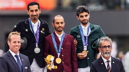 Abdullah Humaid Al Muhairi, left, on the podium with his silver medal after riding Hudson de Vains to second place in the individual show jumping final at the 2026 Asian Games. Photo: UAEOC