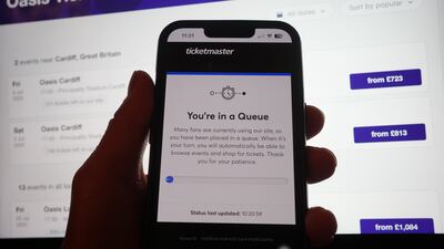 An Oasis fan tries to buy concert tickets via Ticketmaster on their phone. PA Wire