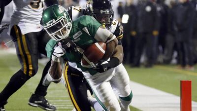 The Saskatchewan Roughriders Kory Sheets scores a tochdown past the Hamilton Tiger-Cats Delvin Breaux. Mark Blinch / Reuters