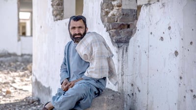A man sits outside the former office of the governor of Nawa-i-Barakzai district that has been bombed and attacked by the Taliban, leaving ruins and bullet-riddled walls. Photo by Stefanie Glinski
