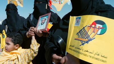 Kuwaiti sisters, from left, Wafa, Latifa and Wadjid hold a photograph in 1999 of their brother Abu Jarrah, one of about 600 prisoners of war taken by Iraq. Reuters