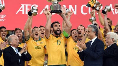 Australia captain Mile Jedinak hoists the Asian Cup trophy after defeating Korea in the final on Saturday. Saeed Khan / AFP