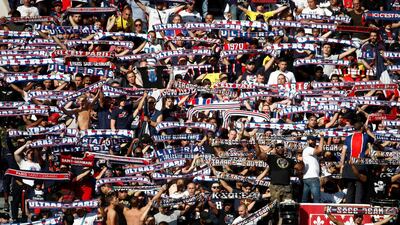 Paris St Germain fans hold up their scarves during the match. Reuters