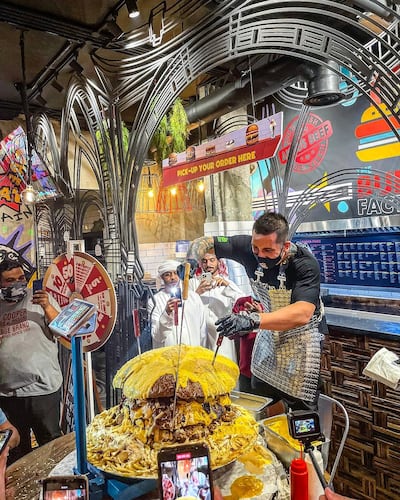 Owner Alin Ciobanu cuts a 68kg burger at The Burgr Factory's newly opened Dubai branch. Courtesy The Burgr Factory